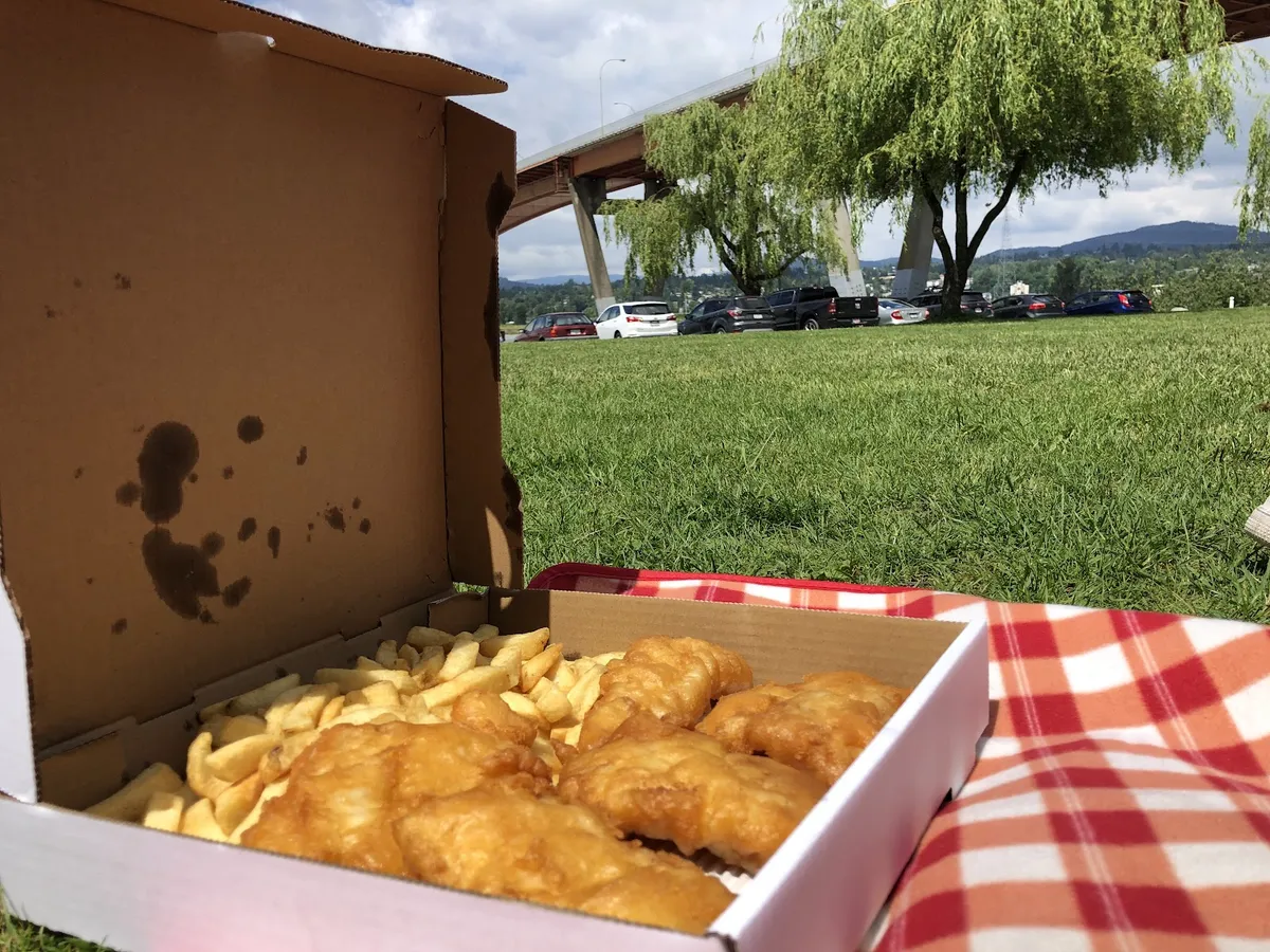 Fish and chips in a box on a picnic blanket