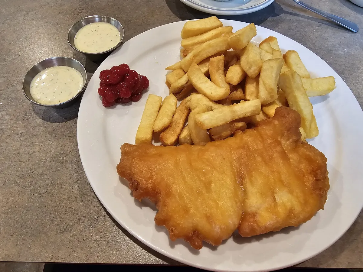 Plate of fish and chips with dipping sauces